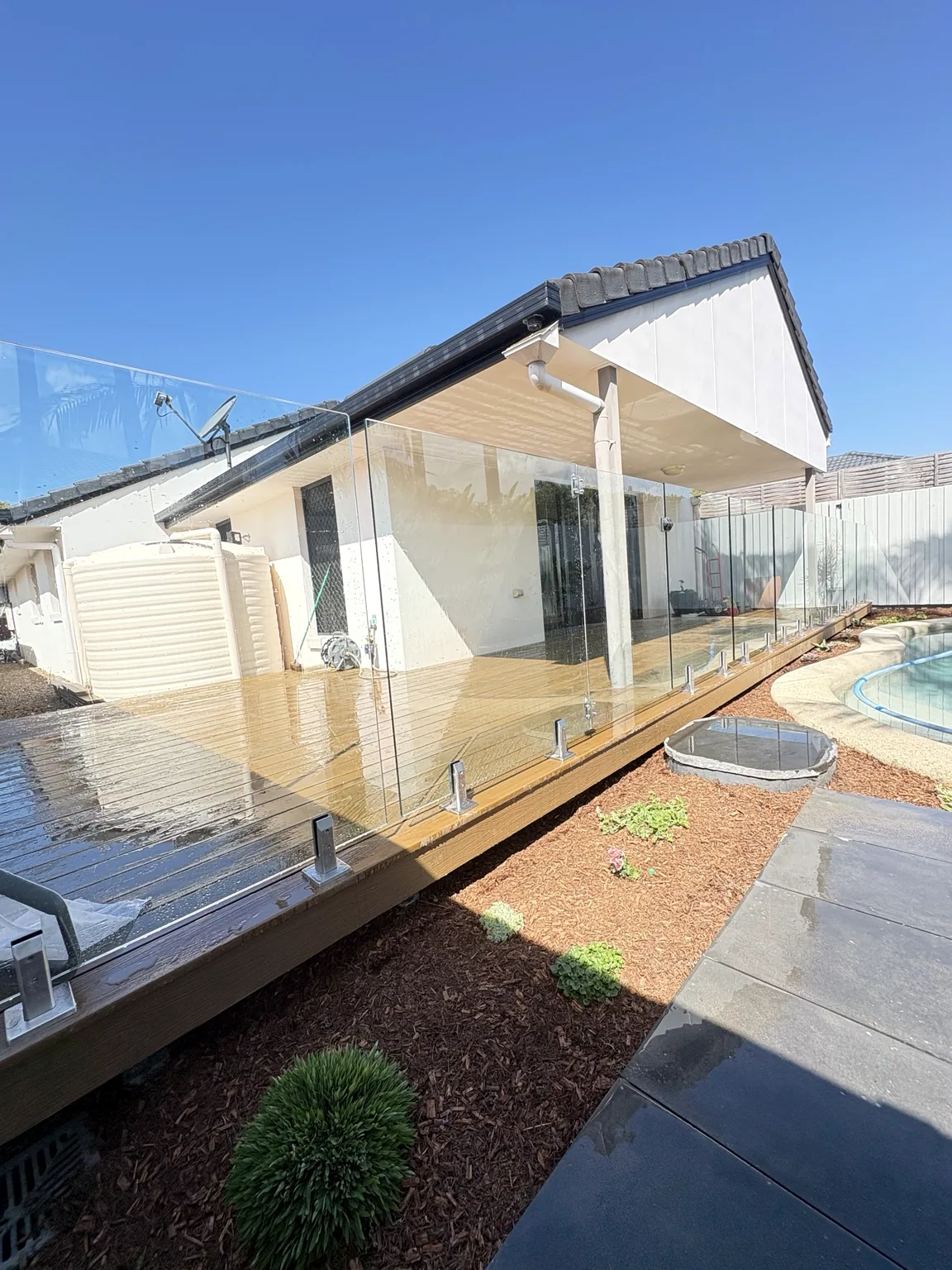 Finished timber pool deck with glass pool fencing